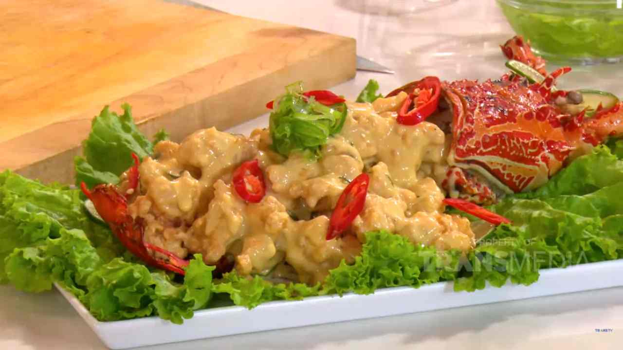 Lobster telur asin dengan saus creamy yang melapisi daging lobster lembut, disajikan dengan hiasan daun kari